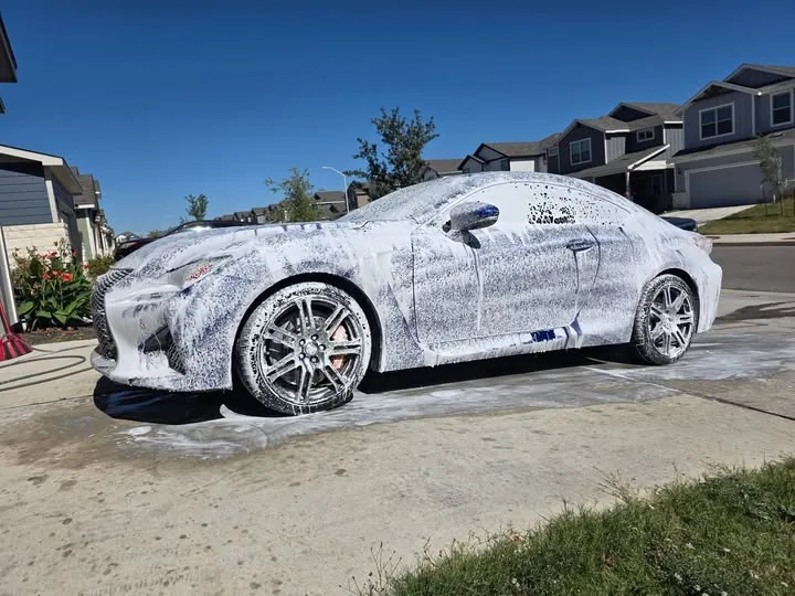 Lexus coupe covered in foam during a foam-cannon exterior wash